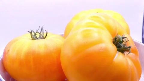 Yellow tomatoes rotating in deep plate on white background 스톡 동영상 344054165