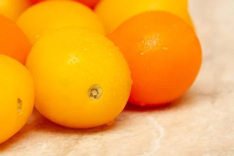 Yellow tomatoes on the table close-up. Stock Photos