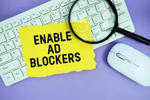 Yellow torn paper with the text "Enable Ad Blockers" placed on a white keyb.. Stock Photos
