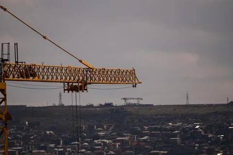Yellow tower crane against the backdrop of the city from a close distance, the Stock-Fotos