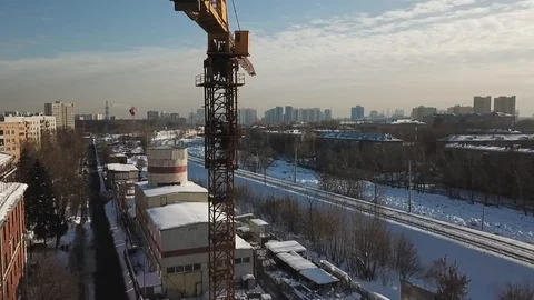 A yellow tower crane on a construction site with many buildings Stock Footage 86870091
