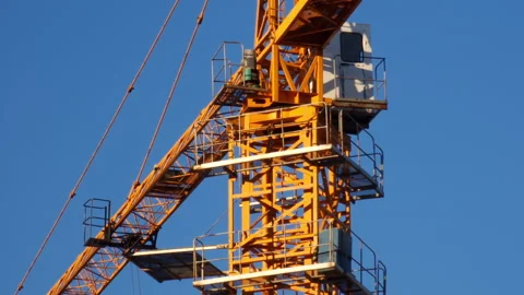 Yellow tower crane on a construction site (detail), against clear blue sky, Stock-Footage 232325416