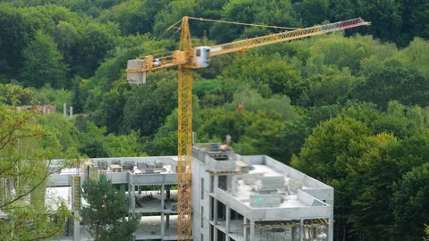 Yellow tower crane stands tall at a construction site. Stock Footage 346656112
