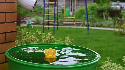 A yellow toy boat float in a green barrel of rainwater. Stock Footage 134156135