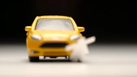Yellow toy car knocks down a female figure on a road - Slow motion Видео 93241254