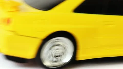 Yellow toy radio-controlled car moves back and forth on white background Stock Footage