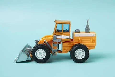 A yellow toy wheel loader construction vehicle Stock Photos