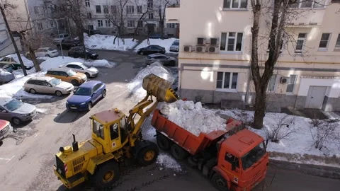 Yellow tractor clears snow from a yard. Stock Footage 327902527
