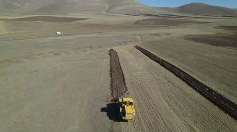 Yellow tractor working in the fields Stock Photos