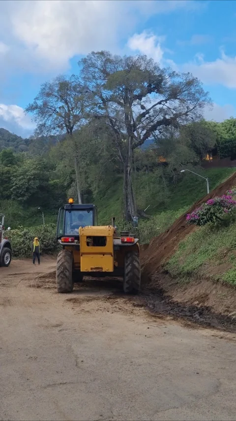 Yellow Tractor Working on Rural Muddy Road Construction Site 스톡 동영상 345101617