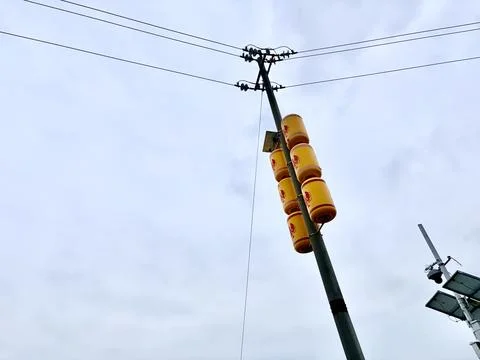 Yellow traffic light on a pole under a cloudy sky. 스톡 사진