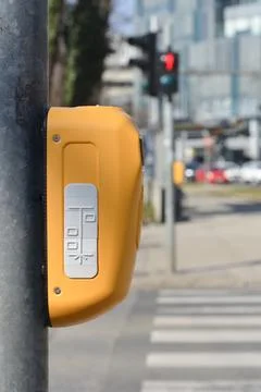 Yellow traffic light pushbutton for pedestrians at crosswalk Stock Photos