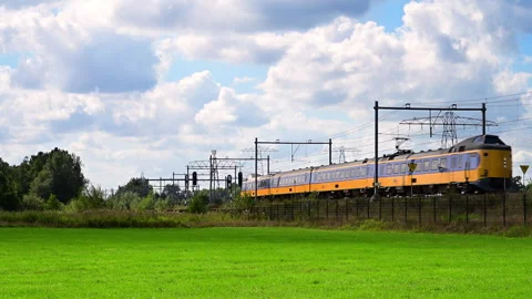 Yellow Train Moving Along Tracks in Netherlands Stock Footage 344394342