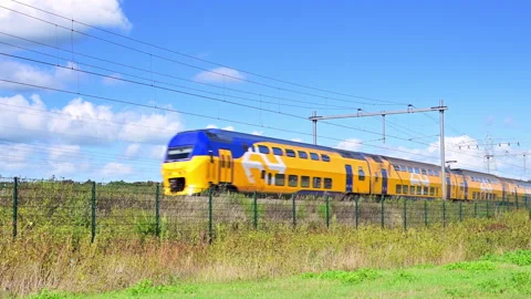 Yellow Train Moving Along Tracks in Netherlands Stock Footage 344394647