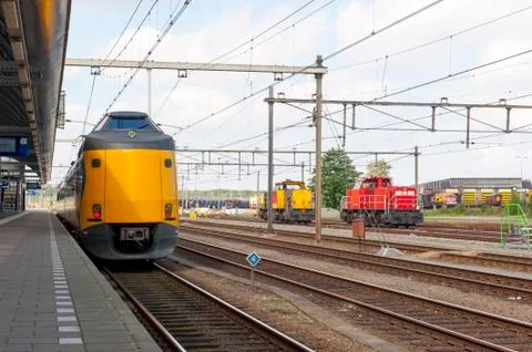 Yellow train at platform of train station Stock Photos