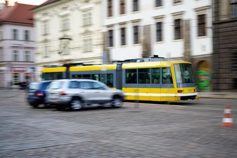 Yellow tram going quickly down the street in motion Stock Photos