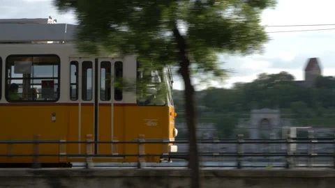 Yellow tram passing by in Budapest next to the Danube Stock Footage 231787262