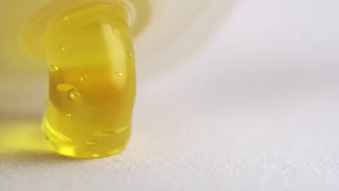 Yellow transparent peeling gel with bubbles pouring of the bottle, macro te.. Stock Footage 261535853