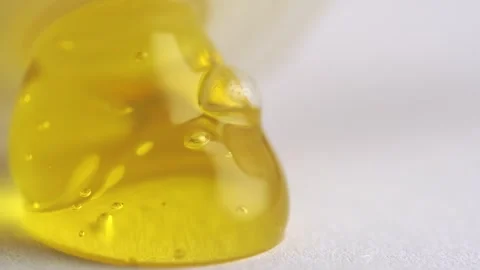 Yellow transparent peeling gel with bubbles pouring of the bottle, macro te.. Stock Footage 262529013