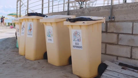 Yellow trash cans for separated waste at the sea beach, garbage recycling Stock Footage 162664510