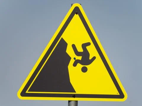 Yellow triangular hazard warning sign on a gray background Stock Photos