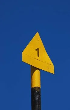 Yellow triangular path marker on blue-sky backgrou Yellow triangular path ... Stock Photos
