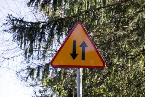 Yellow triangular two-way traffic sign indicating oncoming vehicles with Stock Photos