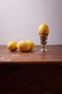 Yellow turmeric painted Easter egg in silver egg cup on rustic table Foto stock