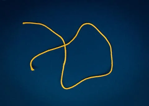 Yellow twisted thread on a canvas background Stock-Fotos