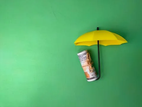 Yellow umbrellas protect the banknotes, save families, prevent risk and the.. Stock Photos