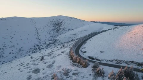 Yellow van driving on winter mountain road, taking big right turn. Scenic Stock Footage 121965934