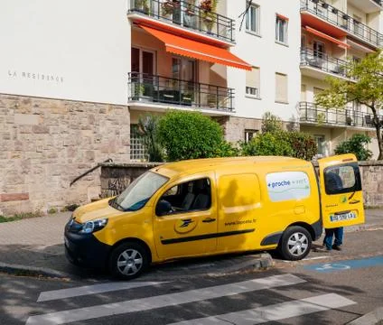 Yellow van la Poste van with worker delivering parcel Stock Photos