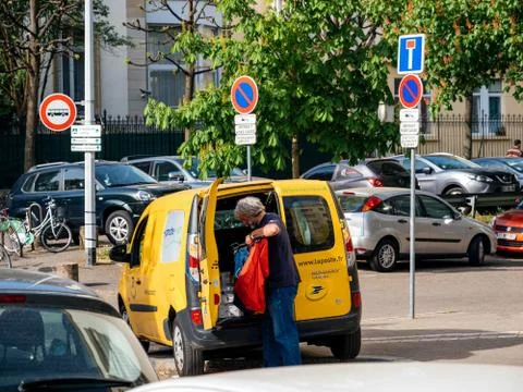 Yellow van la Poste van with worker delivering parcel Stock Photos