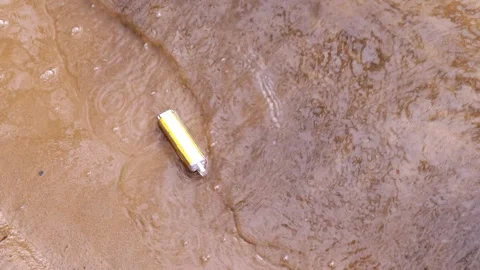 Yellow Vape discarded by a sandy river edge Stock-Footage 264510255