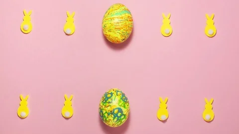 Yellow velvet bunnies and Easter eggs on pink with copy space Stock Footage 123808510