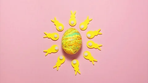 Yellow velvet bunnies around easter egg  on pink Stock Footage 123808501