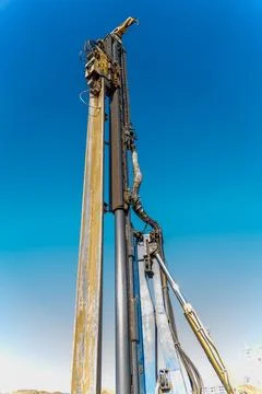 The yellow vibrating piling machine removes Larssen sheet piling from the g.. Stock Photos