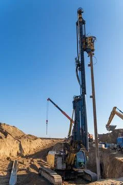 The yellow vibrating piling machine removes Larssen sheet piling from the g.. Stock Photos