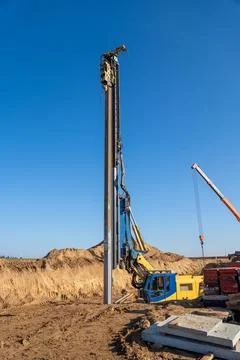 The yellow vibrating piling machine removes Larssen sheet piling from the g.. Stock Photos