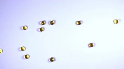 Yellow vitamin balls scatter on the table. Medicine and health Stock Footage 217710902