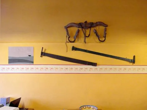 Yellow wall with gray framework and two saws Фото