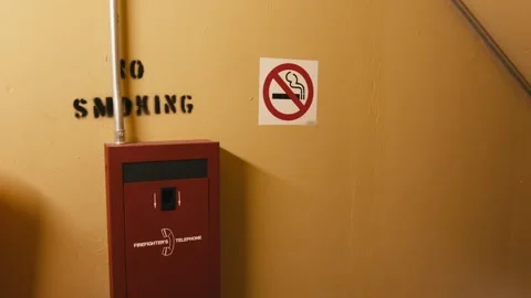 A yellow wall with a red box containing a phone for the firefighters, along with 스톡 동영상 323099764