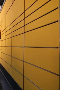 A yellow wall with a row of yellow boxes Stock Photos