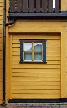 Yellow wall with small window portion in green in Flam, Norway Foto stock