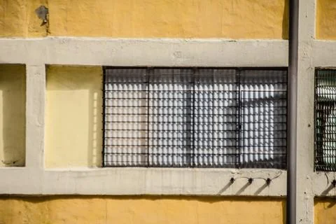 Yellow wall with window grid and shadow pattern Foto stock