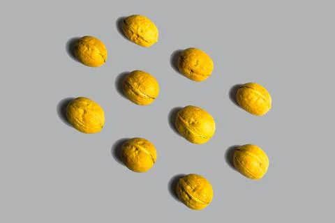 Yellow walnuts in shells lie in rows on pastel gray back. Creative food mocku 写真素材