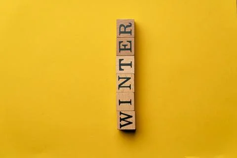 A yellow warm background without shadows wooden cubes with black letters laid Stock Photos