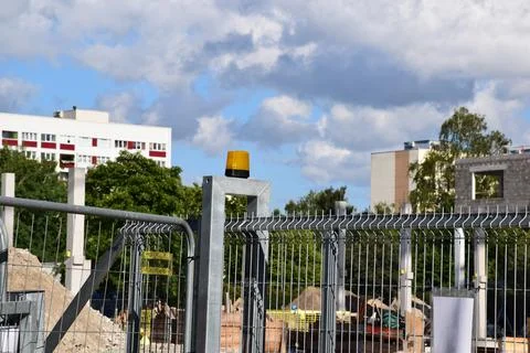 Yellow Warning Beacon on Construction Site Security Fence Stock Photos