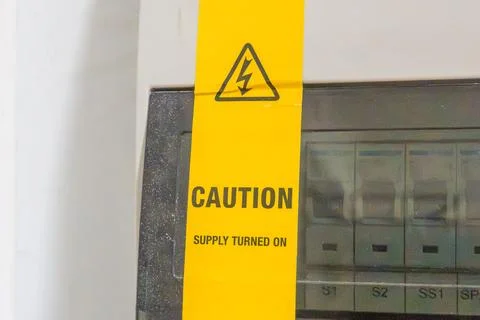Yellow warning tape attached to electrical panel Stock Photos