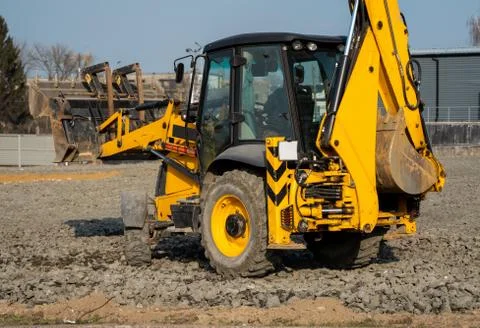 Yellow wheel loader Excavator machine working at construction site with a sand Stock Photos